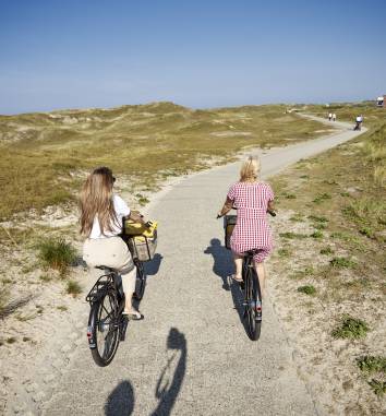 Frauen auf Rädern fahren durch die Dünen von Norderney