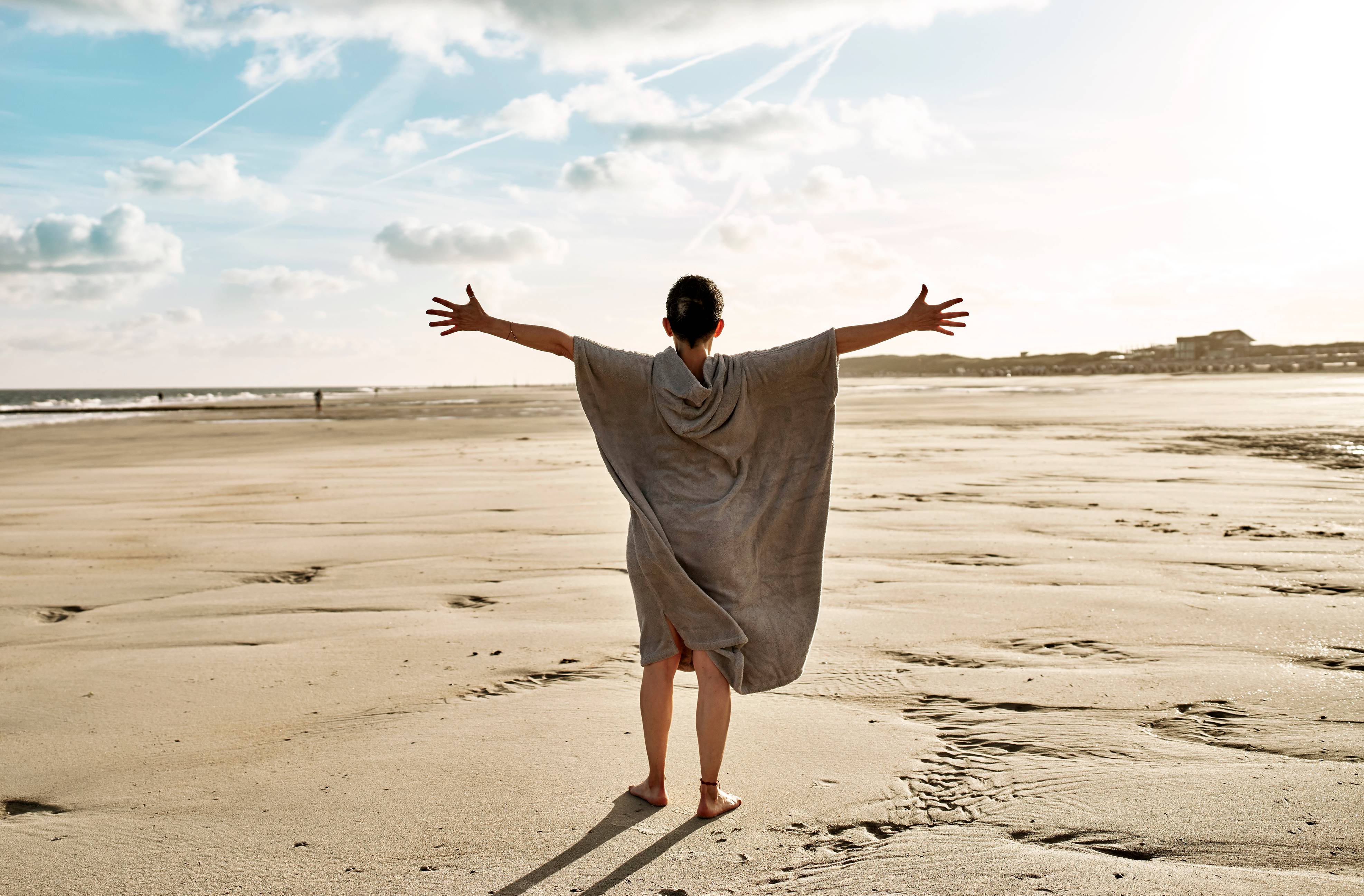 Frau im Handtuchponcho am Strand von Norderney