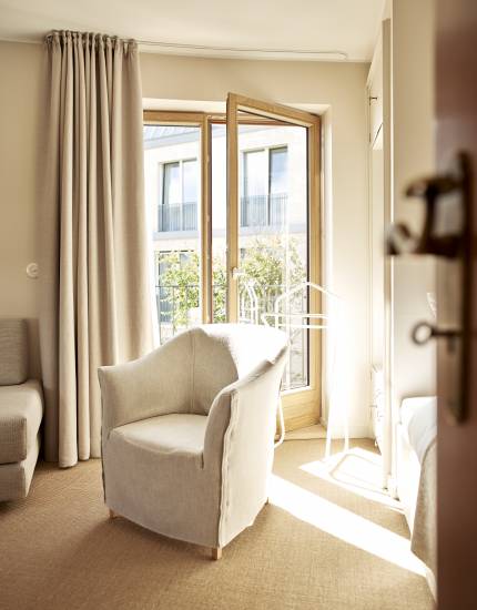 Innenansicht Schlafzimmer mit Sessel und Balkon