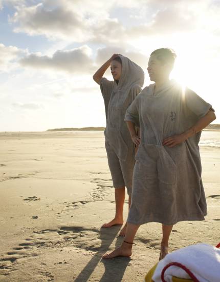 Frauen stehen mit Bademantel am Nordseestrand von Norderney