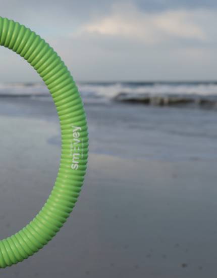 Frau hält einen Smovey Ring am Strand