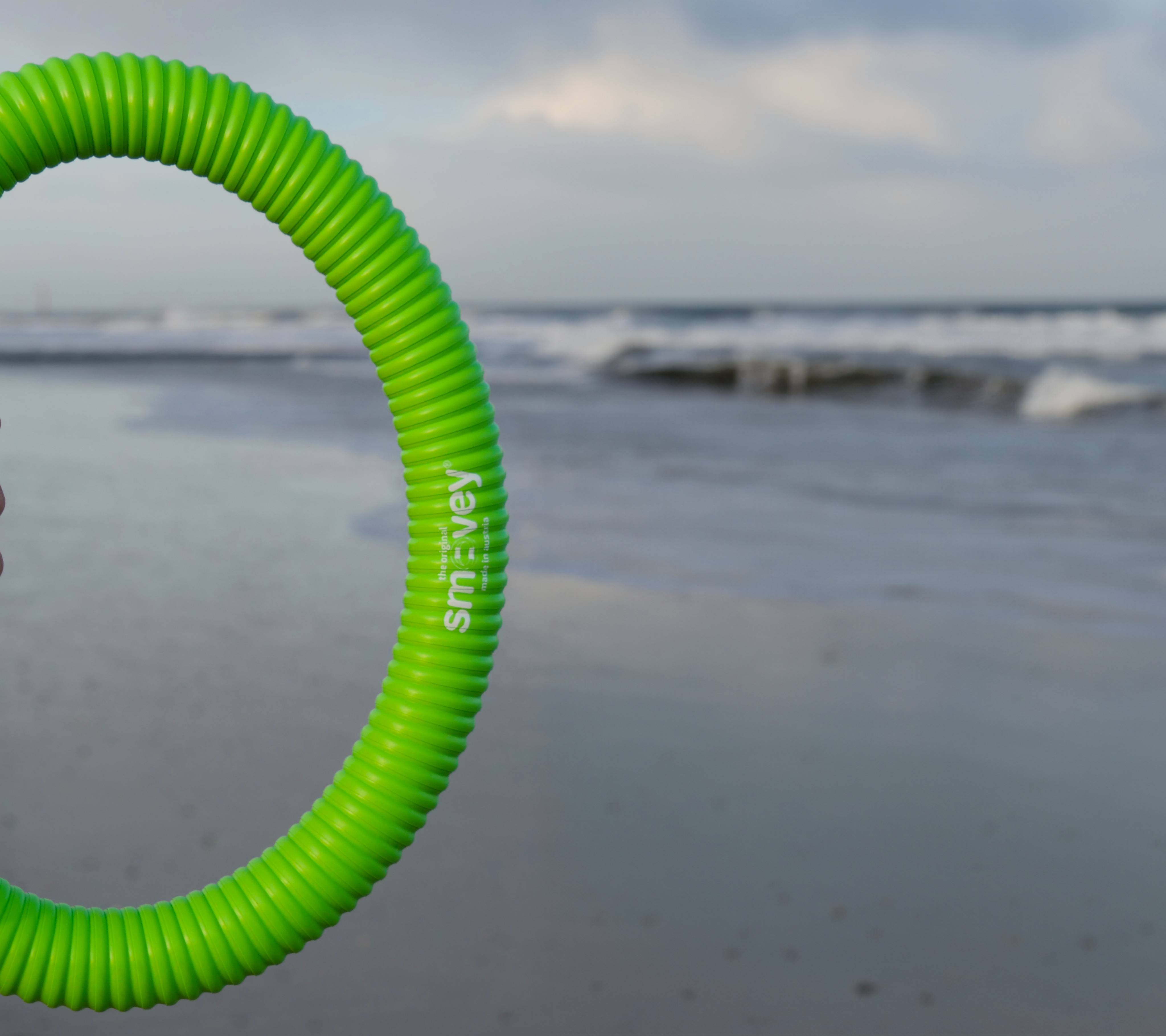 Frau hält einen Smovey Ring am Strand